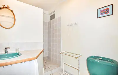a bathroom with a blue toilet and a sink at Maison Piscine Proche Mer in Portel-des-Corbières