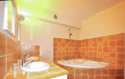 a bathroom with two sinks and a tub at Maison Piscine Proche Mer in Portel-des-Corbières