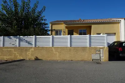 a white fence in front of a house at La Cesse in Bize-Minervois
