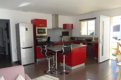 a kitchen with red cabinets and a white refrigerator at La Cesse in Bize-Minervois