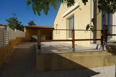 a wooden porch with a wooden railing next to a building at La Cesse in Bize-Minervois