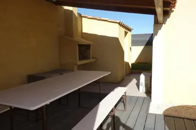 a patio with a table and a counter on a building at La Cesse in Bize-Minervois