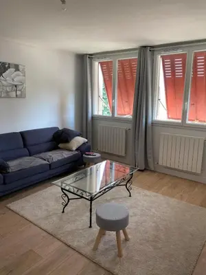 a living room with a blue couch and a glass table at Maison T4 dans ancien corps de ferme avec lac in Gaudiès