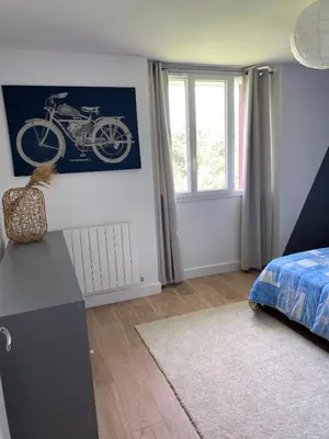 a bedroom with a poster of a motorcycle on the wall at Maison T4 dans ancien corps de ferme avec lac in Gaudiès