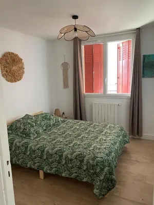 a bedroom with a green bed and a window at Maison T4 dans ancien corps de ferme avec lac in Gaudiès