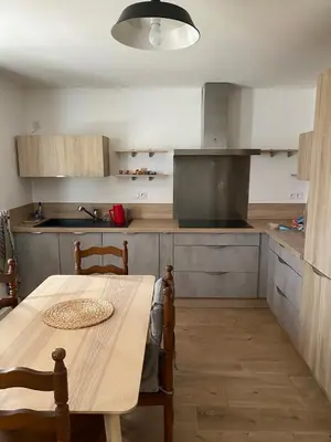 a kitchen with a wooden table and a dining room at Maison T4 dans ancien corps de ferme avec lac in Gaudiès