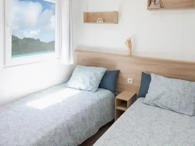 a bedroom with two beds and a window at Mobil-home à Pamiers, 4 Pers, 2 Ch, Terrasse - API-1-52-1950 in Pamiers