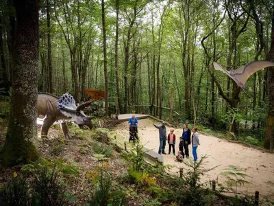 a group of people standing next to a dinosaur statue at Mobil-home cosy pour 2 à Pamiers - API-1-52-1959 in Pamiers