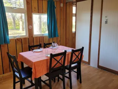 a dining room with a table with chairs and windows at Chalet 6 pers avec Terrasse & Jardin - API-1-52-1952 in Pamiers