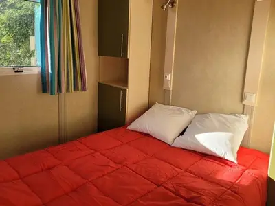 a bedroom with a red bed with two pillows at Chalet Confortable avec Terrasse - 5 pers - API-1-52-1957 in Pamiers