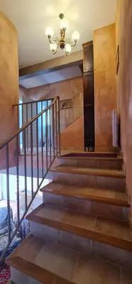 a staircase in a house with a chandelier at L'echappee nature le grand gite in Saint-Benoît