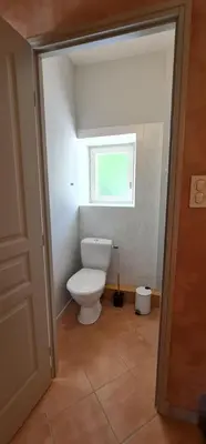 a bathroom with a toilet and a window at L'echappee nature le grand gite in Saint-Benoît
