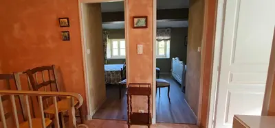 a hallway with a door open to a dining room at L'echappee nature le grand gite in Saint-Benoît