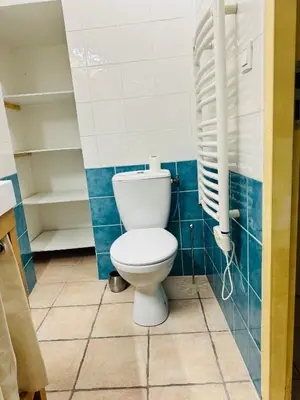 a bathroom with a toilet in a blue tiled room at Maison de village à Roquefort des Corbières in Roquefort-des-Corbières