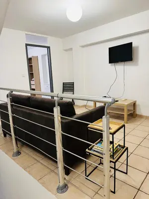 a living room with a couch and a television at Maison de village à Roquefort des Corbières in Roquefort-des-Corbières