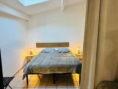 a bedroom with a bed with two night stands and two lamps at Maison de village à Roquefort des Corbières in Roquefort-des-Corbières