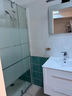 a bathroom with a glass shower and a sink at Maison de village à Roquefort des Corbières in Roquefort-des-Corbières