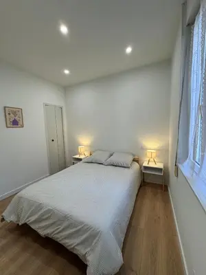 a bedroom with a large bed with two lamps on it at T2 centre-ville rénové avec goût in Narbonne