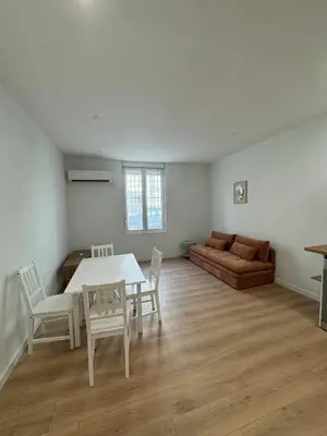 a living room with a table and chairs and a couch at T2 centre-ville rénové avec goût in Narbonne
