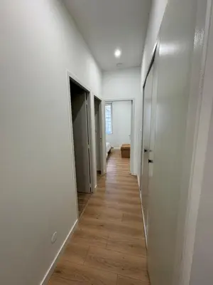 a hallway with white walls and a wooden floor at T2 centre-ville rénové avec goût in Narbonne