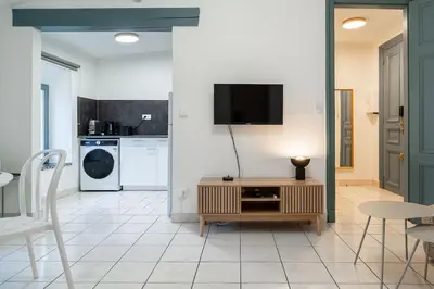 a living room with a tv on a wall at Le Calme des Jacobins Centre de Narbonne in Narbonne