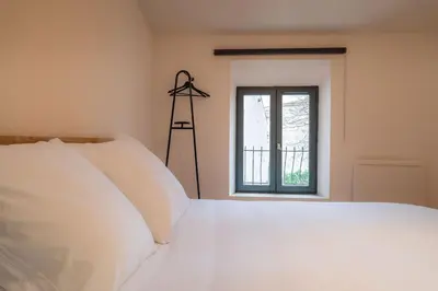 a bedroom with a white bed and a window at Le Calme des Jacobins Centre de Narbonne in Narbonne