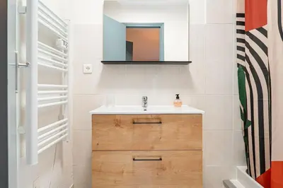 a bathroom with a sink and a mirror at Le Calme des Jacobins Centre de Narbonne in Narbonne