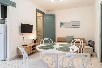 a living room with a white table and chairs at Le Calme des Jacobins Centre de Narbonne in Narbonne