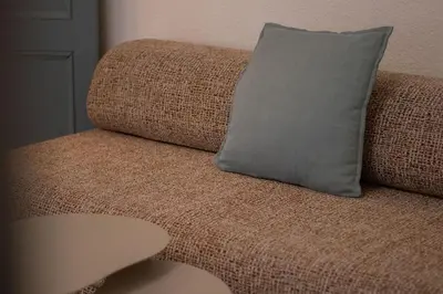a brown couch with a gray pillow on it at Le Calme des Jacobins Centre de Narbonne in Narbonne