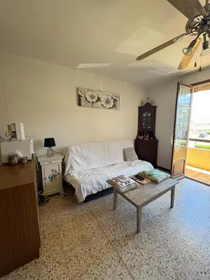 a bedroom with a bed and a table and a window at Appt 4 personnes - balcon - 100 m plage in Port-la-Nouvelle