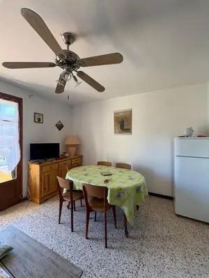 a dining room with a table and a ceiling fan at Appt 4 personnes - balcon - 100 m plage in Port-la-Nouvelle
