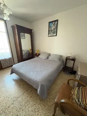 a bedroom with a large bed and a mirror at Appt 4 personnes - balcon - 100 m plage in Port-la-Nouvelle