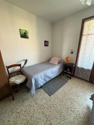 a bedroom with a bed and a chair and a window at Appt 4 personnes - balcon - 100 m plage in Port-la-Nouvelle