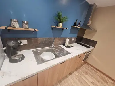 a kitchen with a white refrigerator and a blue wall at modern studio ground floor Wi-Fi TV parking in Salses-le-Chateau