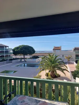 a balcony with a view of a pool at Le Grand Large in Gruissan