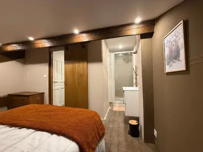 a bedroom with a bed and a bathroom at Maison de village in Montferrier