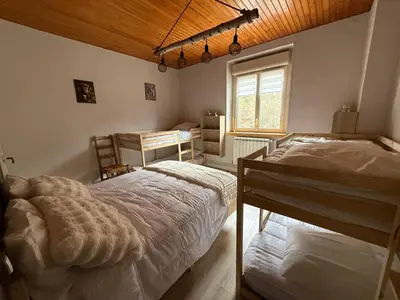a bedroom with two beds and a desk and a window at Maison de village in Montferrier