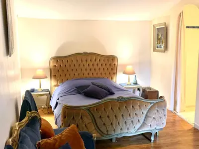 a bedroom with a large bed with purple sheets and pillows at Le Castillou in Luc-sur-Aude
