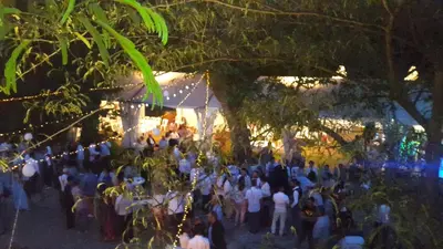 a crowd of people standing under a tent at night at Le Castillou in Luc-sur-Aude