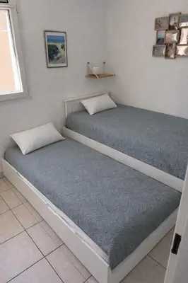 two beds sitting next to each other in a room at Fleur de sel in Gruissan