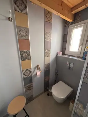 a small bathroom with a toilet and a window at Fleur de sel in Gruissan