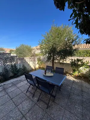 a blue table and chairs on a patio at Fleur de sel in Gruissan