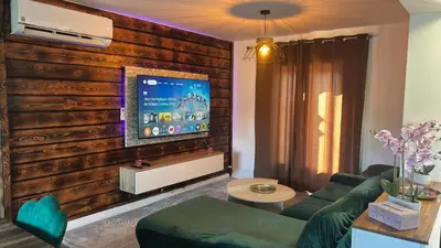a living room with a wooden wall with a flat screen tv at Maison standing 5 chambres Jardin et Garage in Aussillon