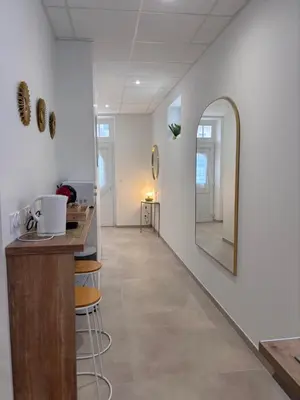 a hallway with a mirror and a counter and stools at Le Diamant in Narbonne