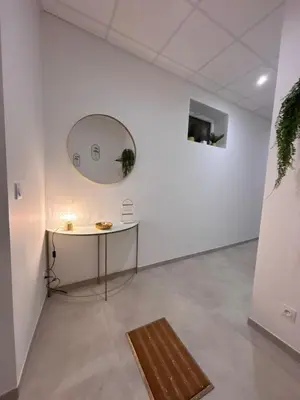 a white room with a table and a mirror at Le Diamant in Narbonne
