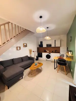 a living room with a couch and a table at Appartement duplex cœur de ville in Narbonne