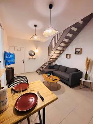 a living room with a couch and a table at Appartement duplex cœur de ville in Narbonne