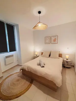 a bedroom with a large bed and a large window at Appartement duplex cœur de ville in Narbonne
