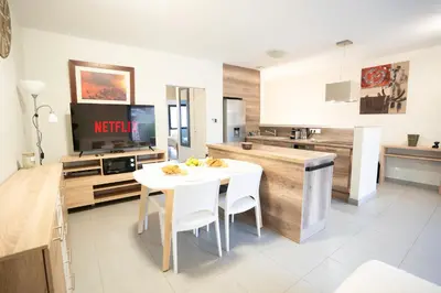 a kitchen and dining room with a white table and chairs at Air-conditioned 2 bedroom apartment with Terrace Parking Carcassonne in Carcassonne
