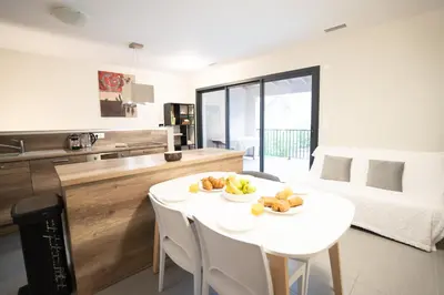 a kitchen and dining room with a white table and chairs at Air-conditioned 2 bedroom apartment with Terrace Parking Carcassonne in Carcassonne